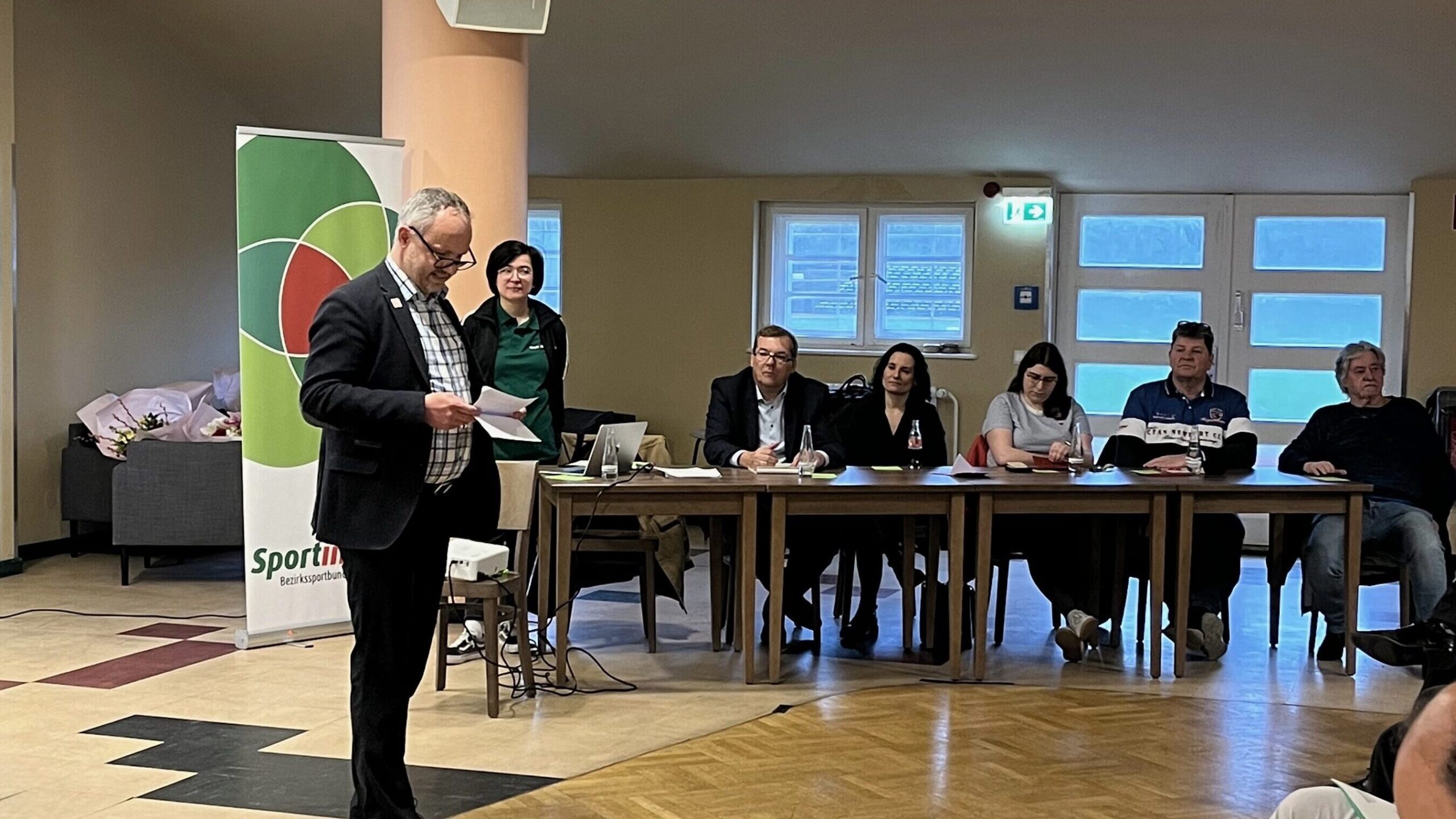 Mario Freund steht vor dem Präsidium und der Versammlung. Er verliest sein Grußwort.